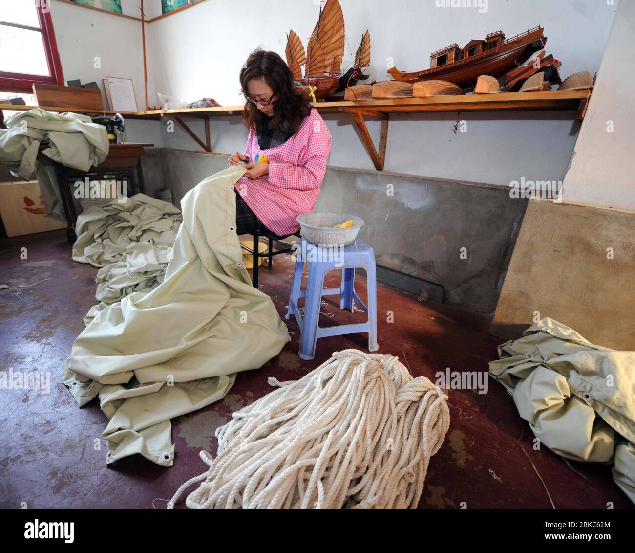 Bildnummer : 54677274 Datum : 25.11.2010 Copyright : imago/Xinhua (101125) -- ZHOUSHAN, 25 novembre 2010 (Xinhua) -- Un ouvrier coud les voiles pour les bateaux à l'atelier du CEN à Zhoushan, province du Zhejiang dans l'est de la Chine, 25 novembre 2010. L'atelier CEN de Zhoushan a une histoire de plus de 100 ans dans la construction de voiliers en bois archaïsés, qui montrent les excellentes compétences chinoises traditionnelles de construction de bateaux, et des pensées de conception uniques avec des caractéristiques régionales. Les compétences artisanales de l'atelier du CEN ont été répertoriées comme l'un des patrimoines culturels immatériels nationaux de la Chine. (Xinhua/Xu Yu) (wyo) CHINE-ZHOUSHAN- Banque D'Images