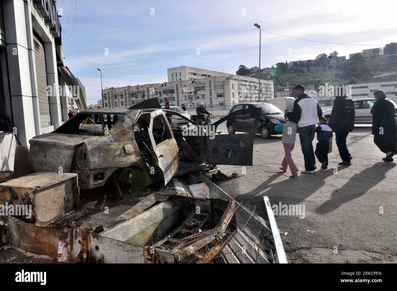 Bildnummer : 54792369 Datum : 07.01.2011 Copyright : imago/Xinhua (110107) -- ALGER, 7 janvier 2011 (Xinhua) -- les habitants passent devant les restes d'une voiture détruite pendant le chaos dans le quartier ouvrier de Bab El-Oued à Alger, Algérie, 7 janvier 2011. Les manifestations qui ont éclaté dans la capitale et dans plusieurs provinces du nord de l'Algérie au sujet du coût élevé de la vie ont conduit au chaos, tandis que les autorités algériennes ont promis de résoudre rapidement la crise de la flambée des prix des grands biens de consommation, ont rapporté vendredi les médias locaux. (Xinhua/Mohamed Kadri) (zl) ALGÉRIE-ALGER-CHAOS PUBLICATIONxNOTxINxCHN P Banque D'Images