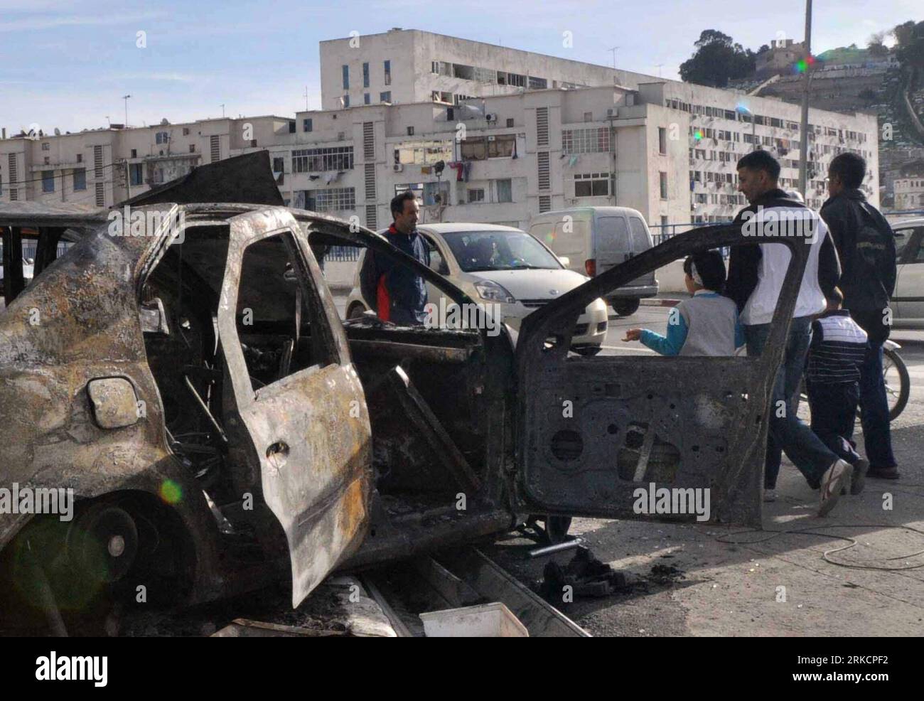 Bildnummer : 54792370 Datum : 07.01.2011 Copyright : imago/Xinhua (110107) -- ALGER, 7 janvier 2011 (Xinhua) -- les habitants passent devant les restes d'une voiture détruite pendant le chaos dans le quartier ouvrier de Bab El-Oued à Alger, Algérie, 7 janvier 2011. Les manifestations qui ont éclaté dans la capitale et dans plusieurs provinces du nord de l'Algérie au sujet du coût élevé de la vie ont conduit au chaos, tandis que les autorités algériennes ont promis de résoudre rapidement la crise de la flambée des prix des grands biens de consommation, ont rapporté vendredi les médias locaux. (Xinhua/Mohamed Kadri) (zl) ALGÉRIE-ALGER-CHAOS PUBLICATIONxNOTxINxCHN P Banque D'Images