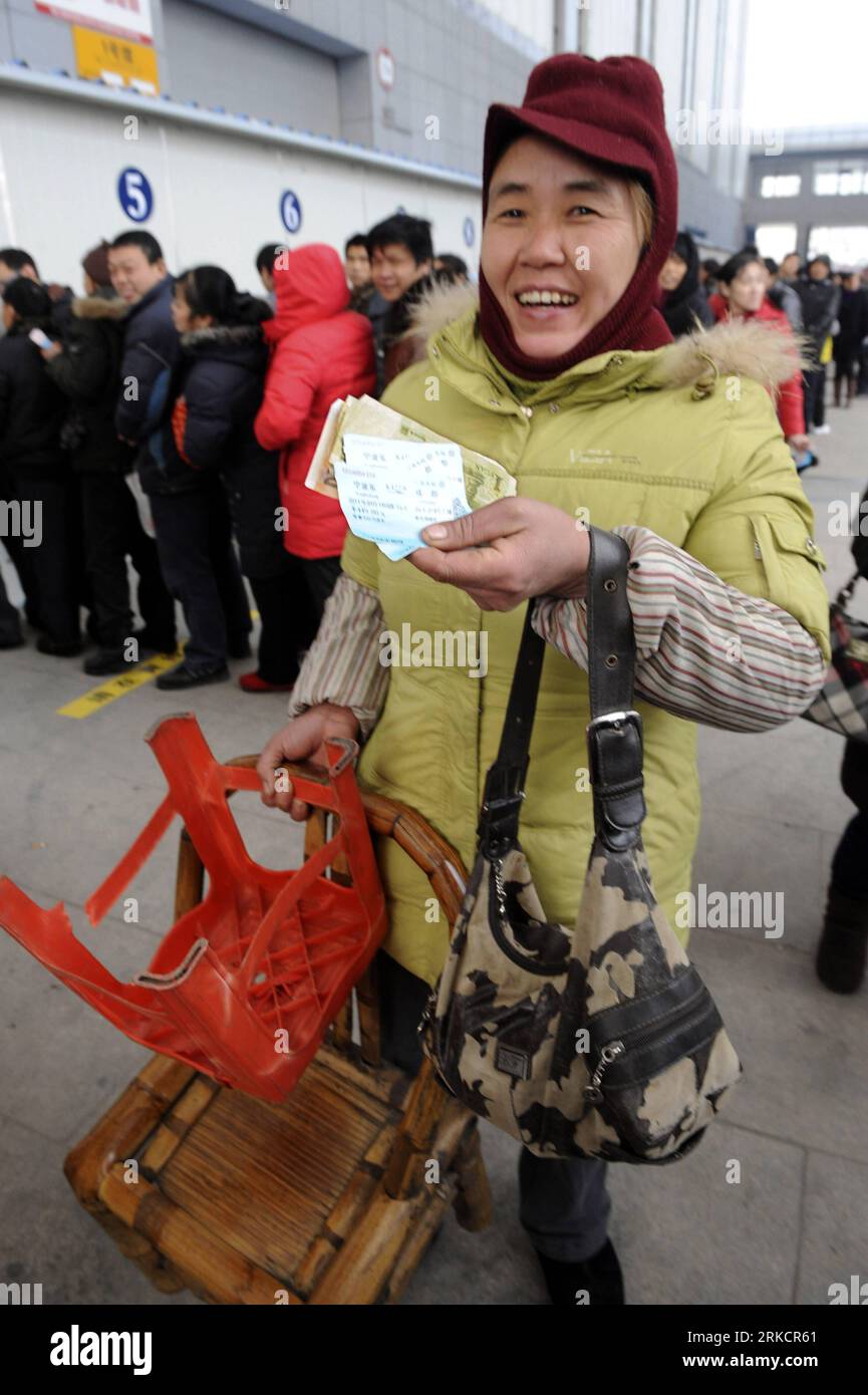 Bildnummer : 54795191 Datum : 09.01.2011 Copyright : imago/Xinhua (110109) -- NINGBO, 9 Jan. 2011 (Xinhua) -- Une travailleuse migrante nommée Yuan Fenghua montre ses billets de train au Centre international de congrès et d'exposition de Ningbo dans la ville de Ningbo, dans la province du Zhejiang dans l'est de la Chine, le 9 janvier 2011. Une billetterie de train temporaire a été inaugurée ici dimanche pour détourner les foules d'achat des gares fortement encombrées. Chaque année, des millions de Chinois retournent chez eux pour des réunions de famille pendant la saison de voyage du Festival du printemps, ce qui entraîne une pression interprovinciale du trafic de passagers dans le grand nombre Banque D'Images
