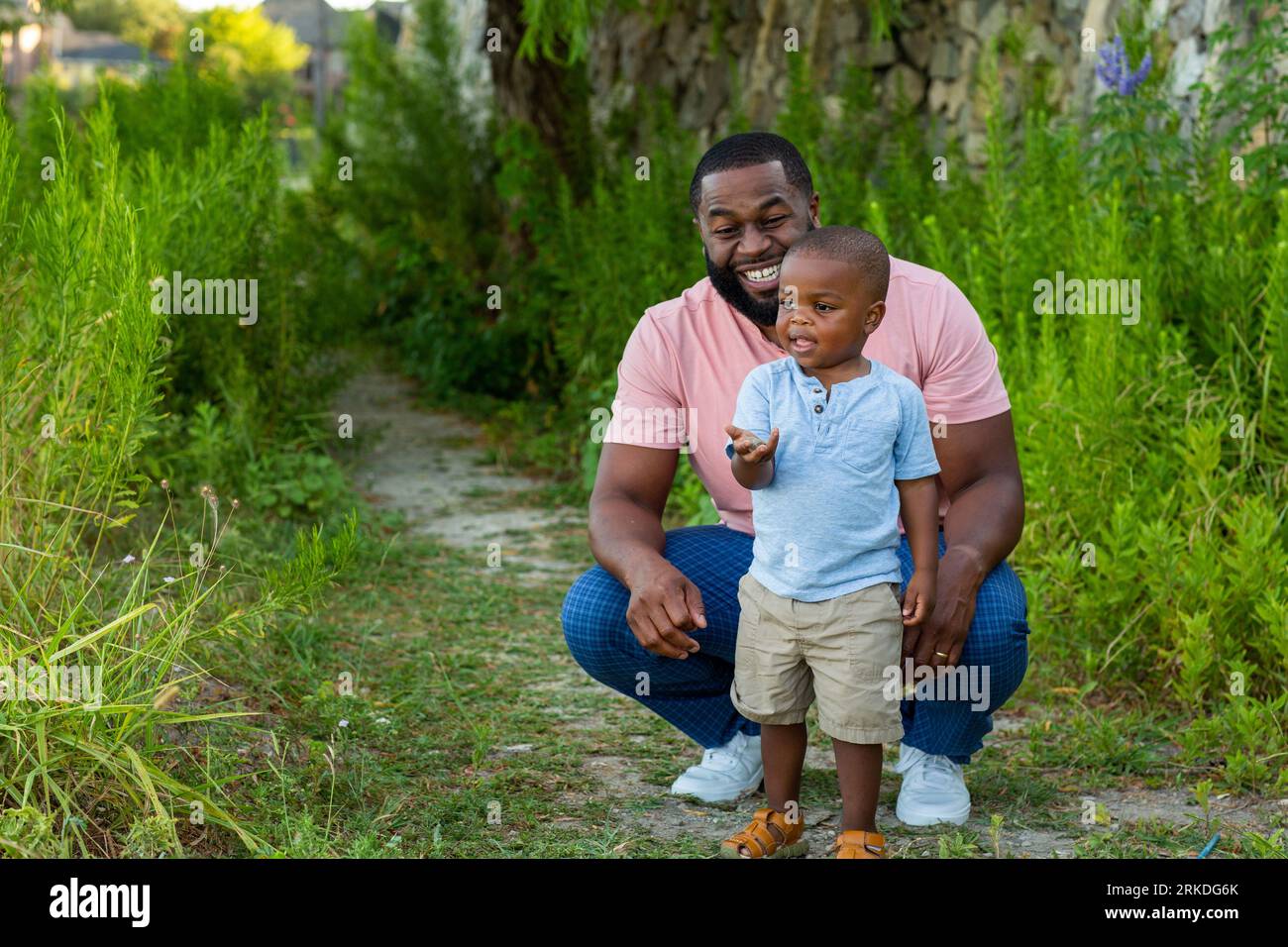 Homme afro-américain jouant et jetant des pierres avec son fils. Banque D'Images