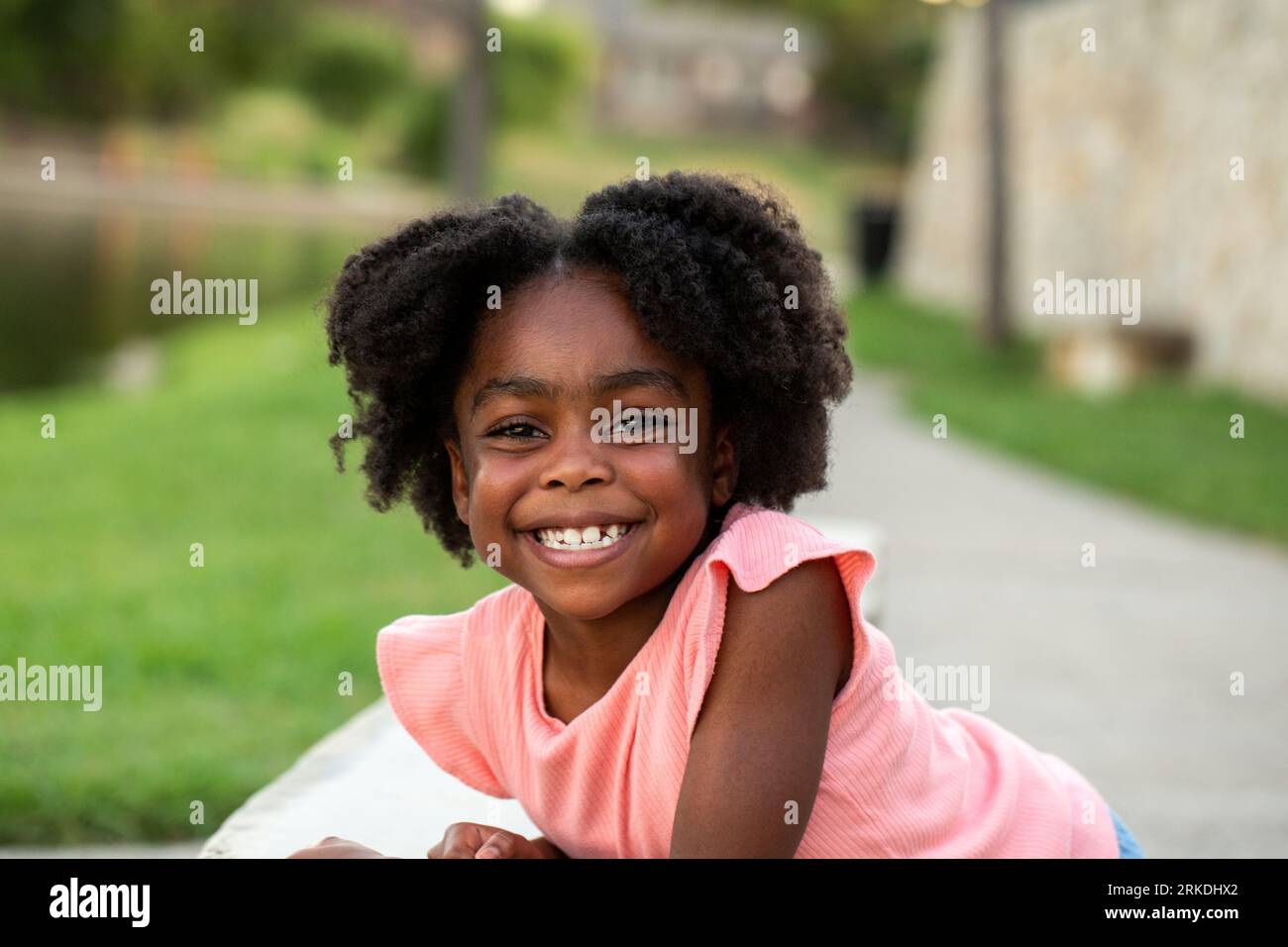 Petite fille africaine américaine souriante à l'extérieur. Banque D'Images