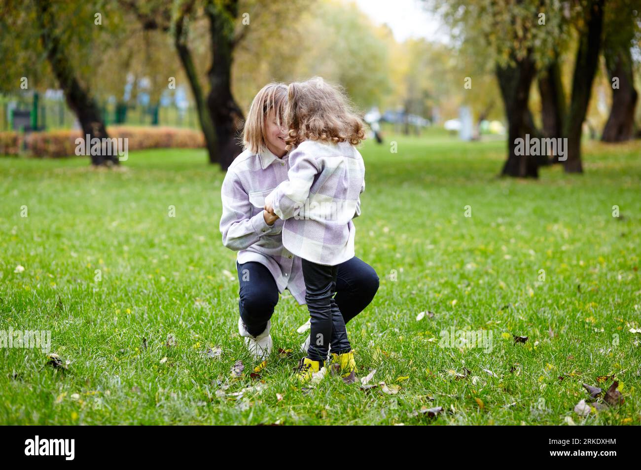 Bonjour octobre. Mère et fille marchent dans le parc de la ville d'automne. Parent et petit enfant s'amusant à l'extérieur Banque D'Images