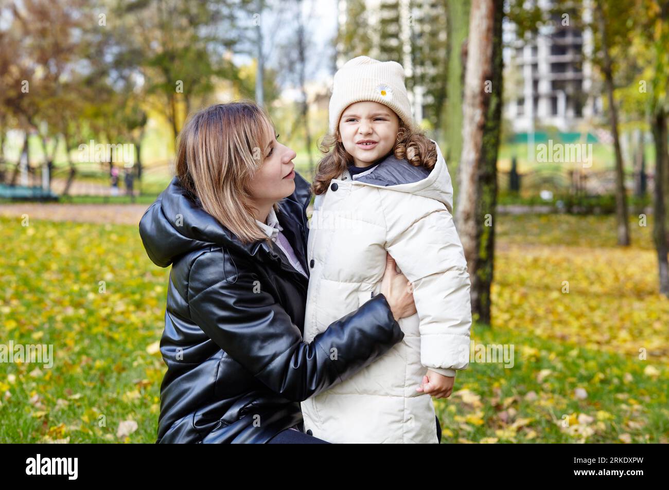 Bonjour octobre. Mère et fille marchent dans le parc de la ville d'automne. Parent et petit enfant s'amusant à l'extérieur Banque D'Images