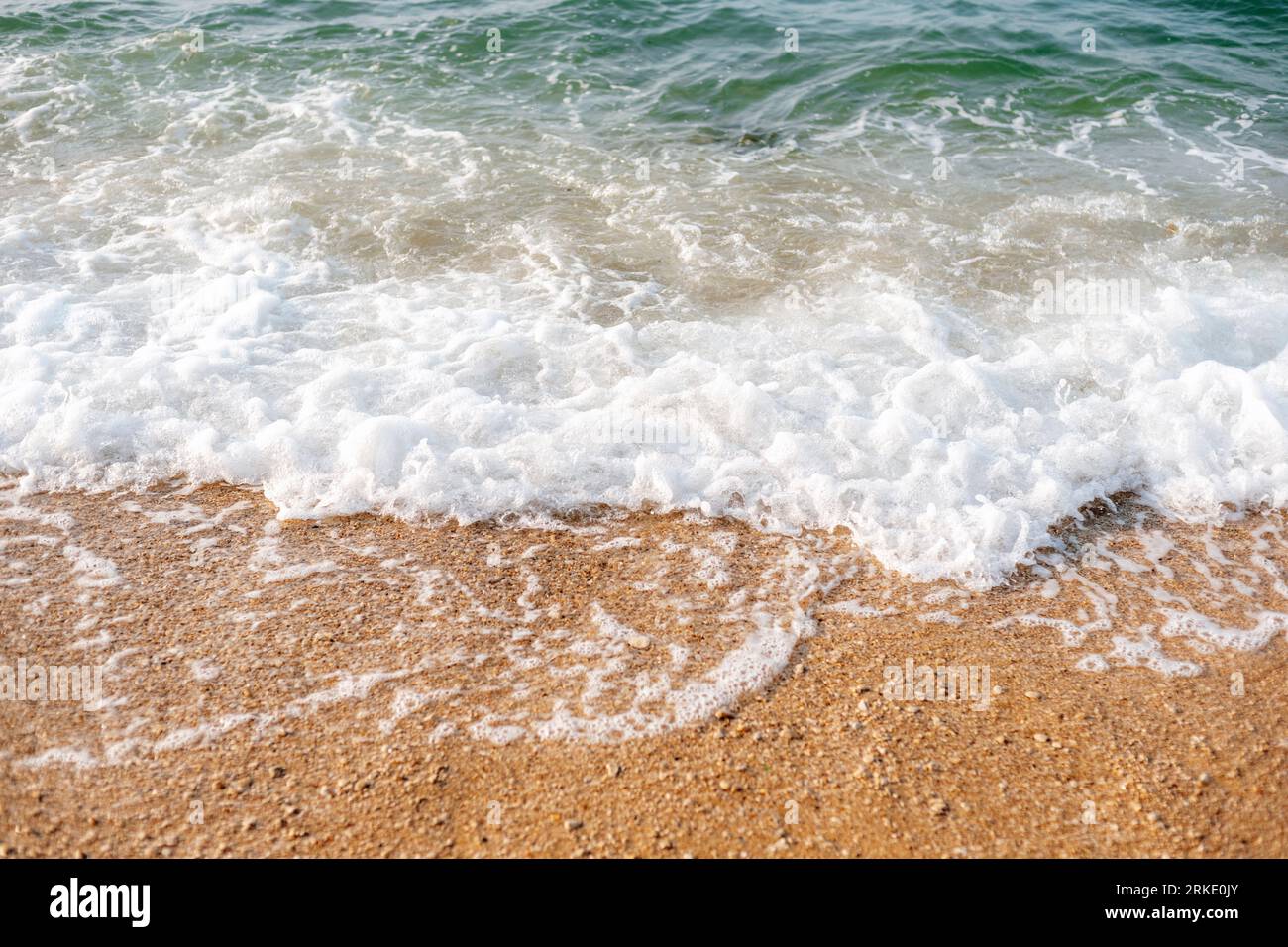 Vagues de mer et mousse sur la plage, vue de dessus. Banque D'Images