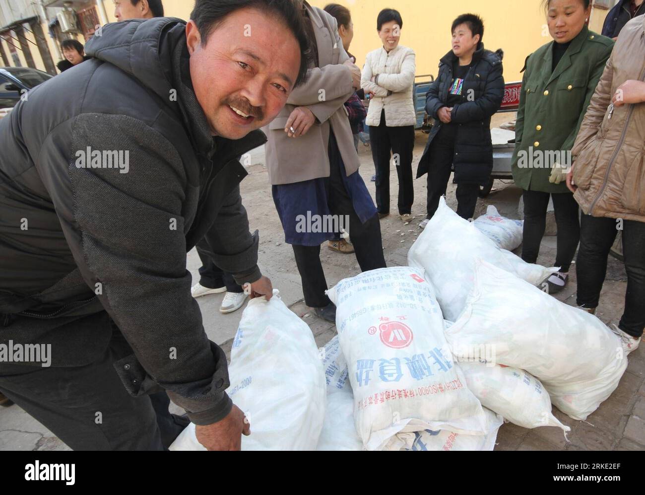 Bildnummer : 55041075 Datum : 17.03.2011 Copyright : imago/Xinhua (110318) -- SHANGQIU, 18 mars 2011 (Xinhua) -- Un marchand de sel sourit alors qu'il achetait du sel à Shangqiu, dans la province du Henan du centre de la Chine, le 17 mars 2011. La Commission nationale pour le développement et la réforme a promis un approvisionnement suffisant en produits de première nécessité quotidiens, y compris le sel, affirmant qu’elle travaillerait avec les agences compétentes pour répondre à la demande du marché et maintenir la stabilité des prix. Les supermarchés dans de nombreuses villes chinoises ont manqué de sel car une vague d’achat de panique a résulté de rumeurs selon lesquelles les radiations de la centrale nucléaire de Fukushima Daiichi ont fui dans la mer Banque D'Images