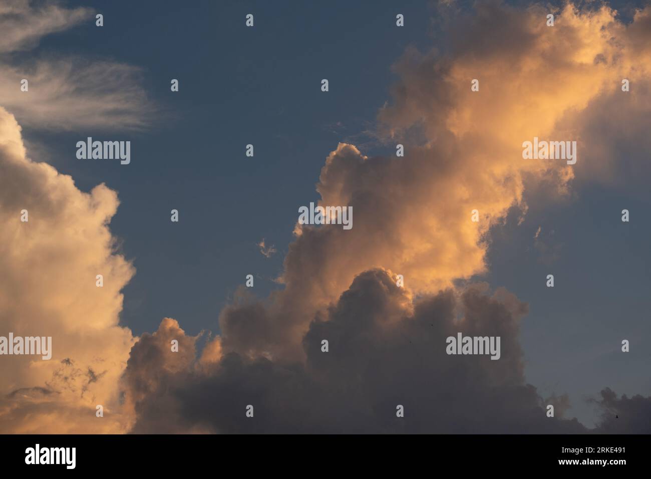 Une photo captivante capture le ciel serein du soir tandis que le soleil descendant baigne le monde d'une lueur chaude et dorée. Les teintes du ciel dépeignent à couper le souffle Banque D'Images