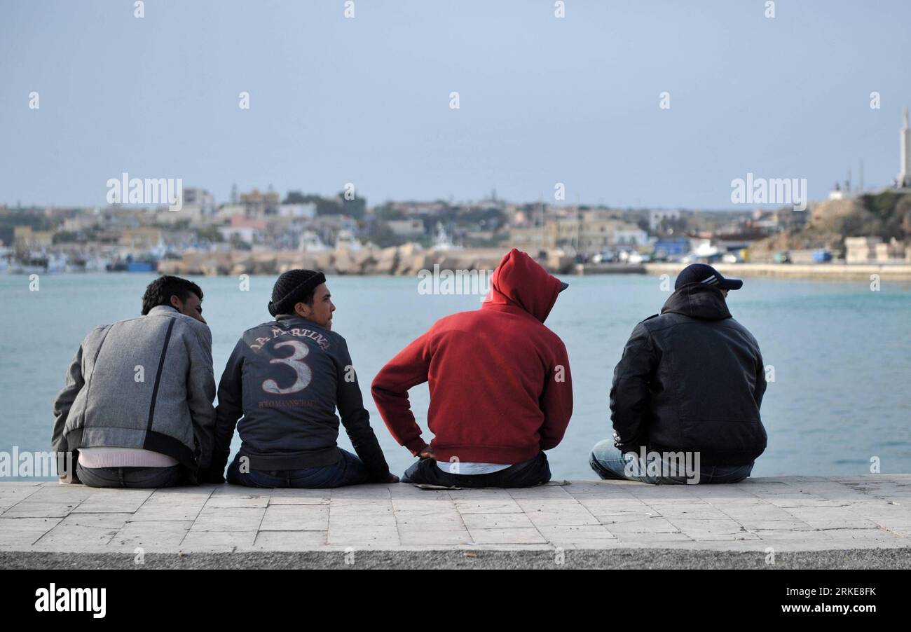 (110328) -- LAMPEDUSA, 28 mars 2011 (Xinhua) -- un immigrant illégal d'Afrique du Nord attend à un quai sur l'île de Lampedusa, à l'extrême sud de l'Italie, le 28 mars 2011. Un autre afflux de quelque 3 700 000 immigrants a afflué à Lampedusa ces derniers jours à la suite des troubles en Tunisie et en Libye. L'Italie enverra six navires d'une capacité totale de 10 000 mercredi pour alléger la pression sur l'île surpeuplée du sud. (Xinhua/Wang Qingqin) (zw) ITALIE-LAMPEDUSA-LIBYE-IMMIGRANTS NORD-AFRICAINS PUBLICATIONxNOTxINxCHN LAMPEDUSA Mars 28 2011 XINHUA immigrant illégal d'Afrique du Nord attend à un quai SUR LAMPEDUS Banque D'Images