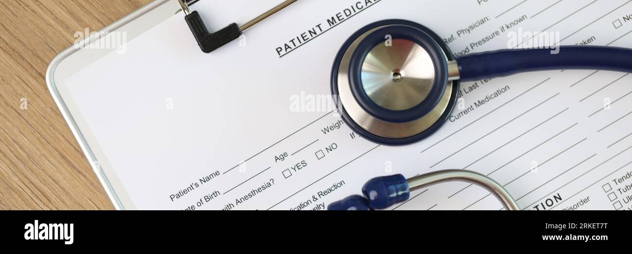 Feuille vierge de la forme des antécédents médicaux du patient avec stéthoscope et pilules, vue du dessus. Banque D'Images