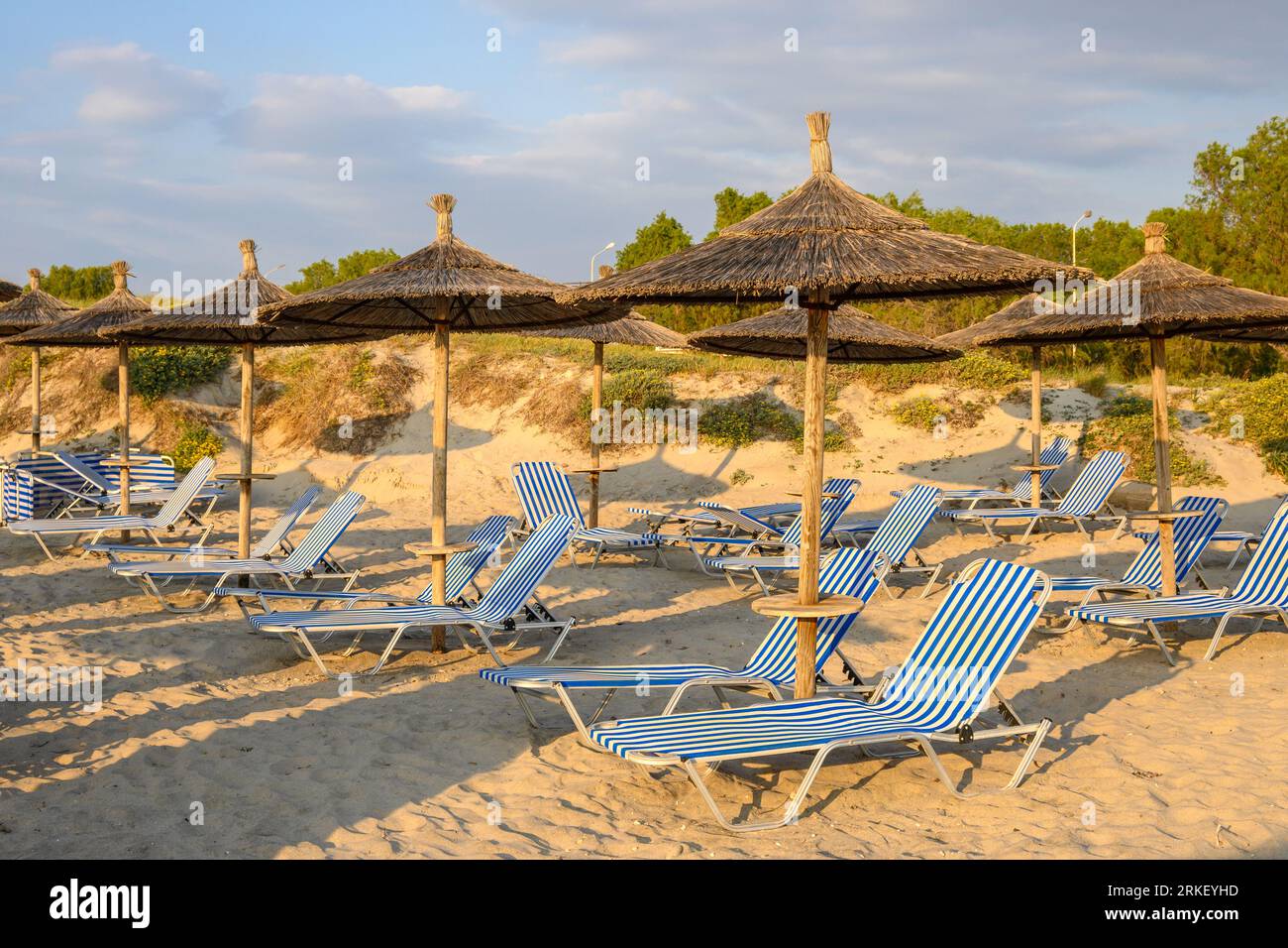 Transats avec parasol sur la plage de sable de Marmari. L'île grecque de Kos Banque D'Images