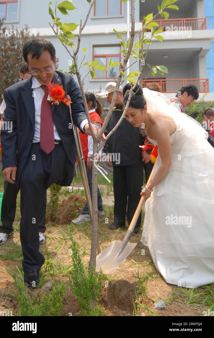 Bildnummer : 55348611 Datum : 15.05.2011 Copyright : imago/Xinhua (110515) -- WEIFANG, 15 mai 2011 (Xinhua) -- Un couple de jeunes mariés plante un arbre du bonheur lors d'un mariage de masse pour handicapés à Weifang, dans la province du Shandong de l'est de la Chine, le 15 mai 2011. Le premier mariage de masse pour les handicapés, avec la participation de 18 couples, a eu lieu dans la ville de Weifang le dimanche, la 21e Journée nationale de l'aide aux handicapés, avec pour thème l'amélioration des moyens de subsistance des handicapés, la protection des droits et des intérêts des handicapés. (Xinhua/CAO Lianghua)(zxh) CHINE-SHANDONG-JOURNÉE NATIONALE D'AIDE AUX HANDICAPÉS-COLLECTIF NOUS Banque D'Images