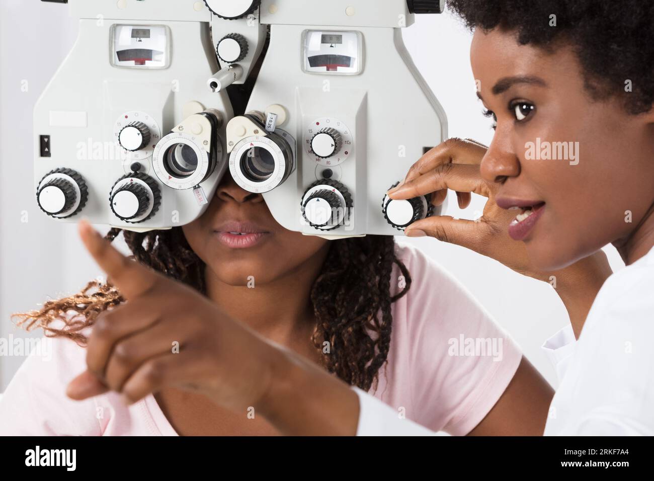 Opticien effectuant un examen oculaire d'optométrie pour patient noir africain Banque D'Images