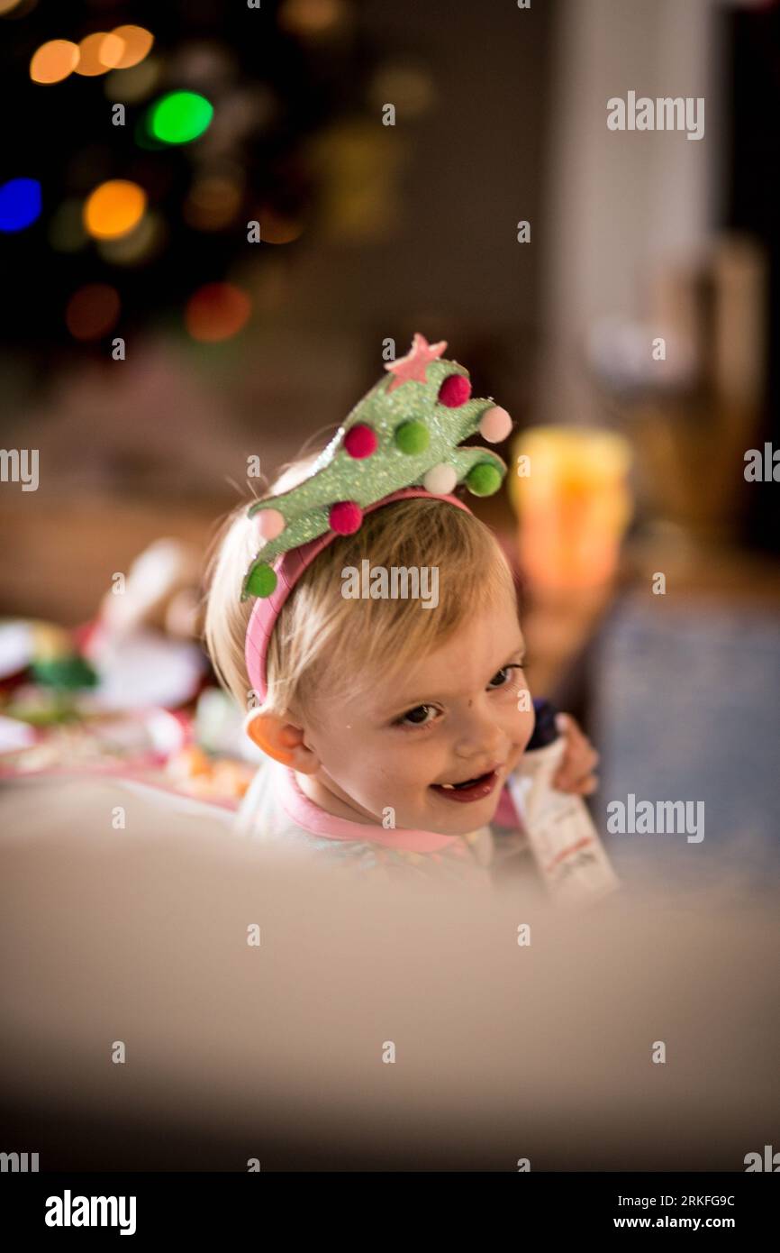 tout-petits / bébé portant un serre-tête sapin de noël avec bokeh Banque D'Images