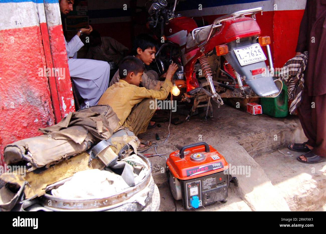 Bildnummer : 55470420 Datum : 17.06.2011 Copyright : imago/Xinhua (110617) -- PESHAWAR, 17 juin 2011 (Xinhua) -- des garçons réparent une moto tout en utilisant un générateur électrique pour l'éclairage pendant la mise hors tension dans le nord-ouest du Pakistan Peshawar le 17 juin 2011. Un porte-parole de la Pakistan Electric Power Company (PEPCO) a déclaré que la demande d'électricité dans le pays dépasse l'offre de 4 000 mégawatts. (Xinhua photo/Saeed Ahmad) (lyx) PAKISTAN-PÉNURIE D'ÉLECTRICITÉ PUBLICATIONxNOTxINxCHN Gesellschaft xub 2011 quer o0 Arbeitswelten Werkstatt Motorrad Bildnummer 55470420 Date 17 06 201 Banque D'Images