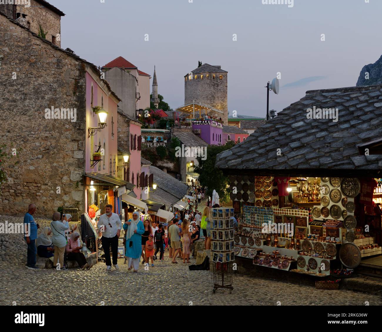 Les touristes marchent dans une rue pavée avec des boutiques de souvenirs dans la vieille ville de Mostar un soir d'été, Bosnie-Herzégovine, 20 août 2023. Banque D'Images