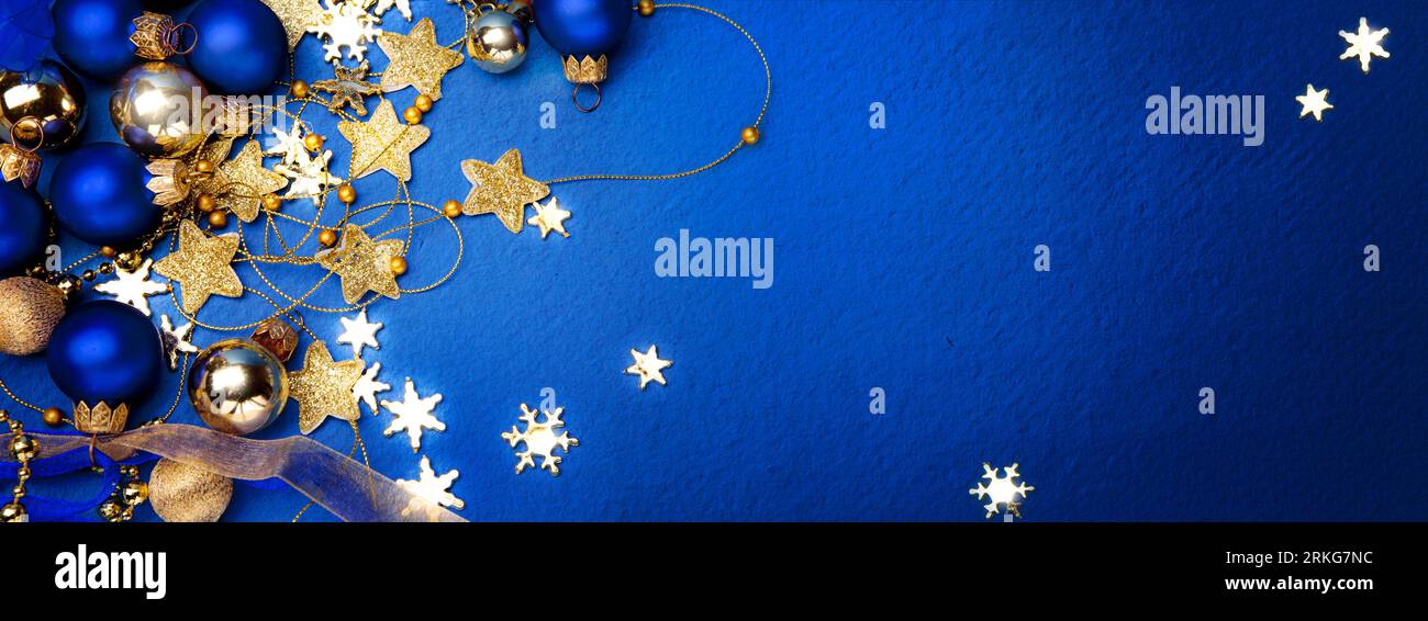Motif banderole de Noël ou carte de vœux. Branche d'arbre de Noël décorée de boules de couleur dorée et d'étoiles sur fond bleu. Large maquette de Noël, il Banque D'Images