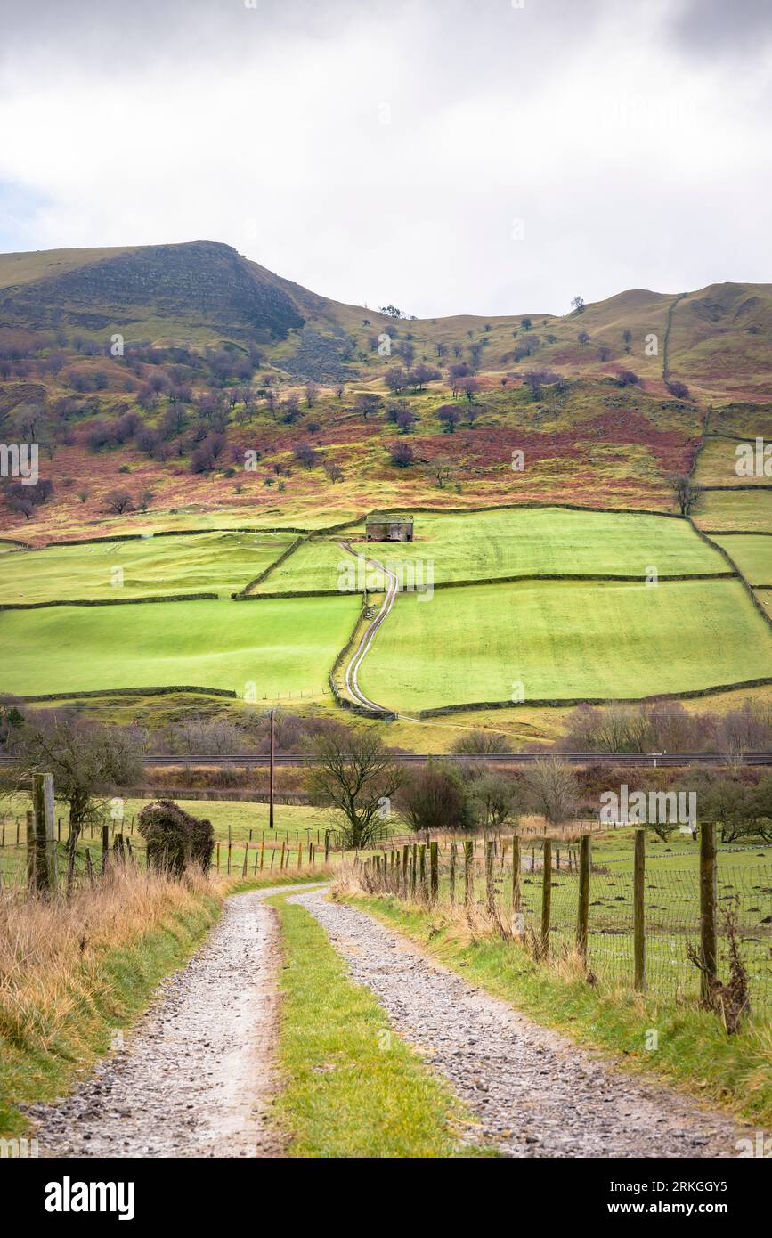 Campagne du Derbyshire en hiver avec piste agricole dans la vallée de l'espoir, avec une ancienne grange en pierre et Back Tor en arrière-plan. Peak District, Derbyshire, Royaume-Uni Banque D'Images