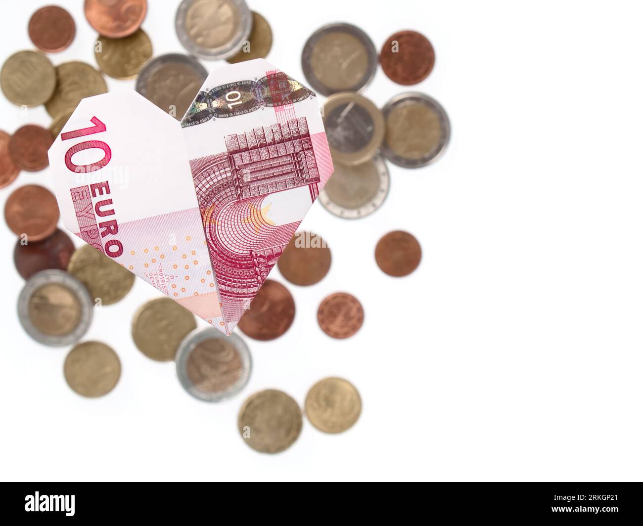Un gros plan d'un coeur d'un billet de dix euros plié, avec un fond blanc Banque D'Images
