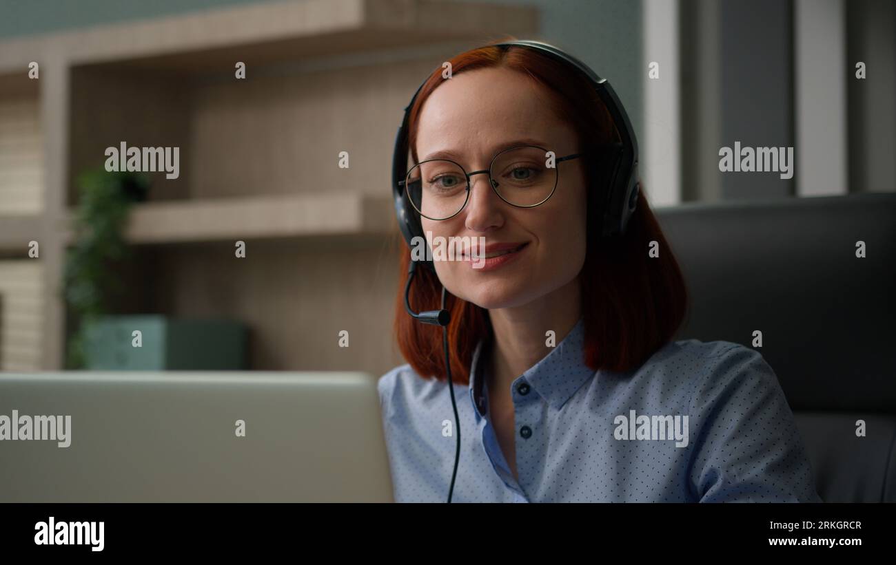 Femme caucasienne souriante avec casque parlant ordinateur portable appel vidéo fille parler travailler service clientèle opérateur d'assistance téléphonique agent au bureau appelant Banque D'Images