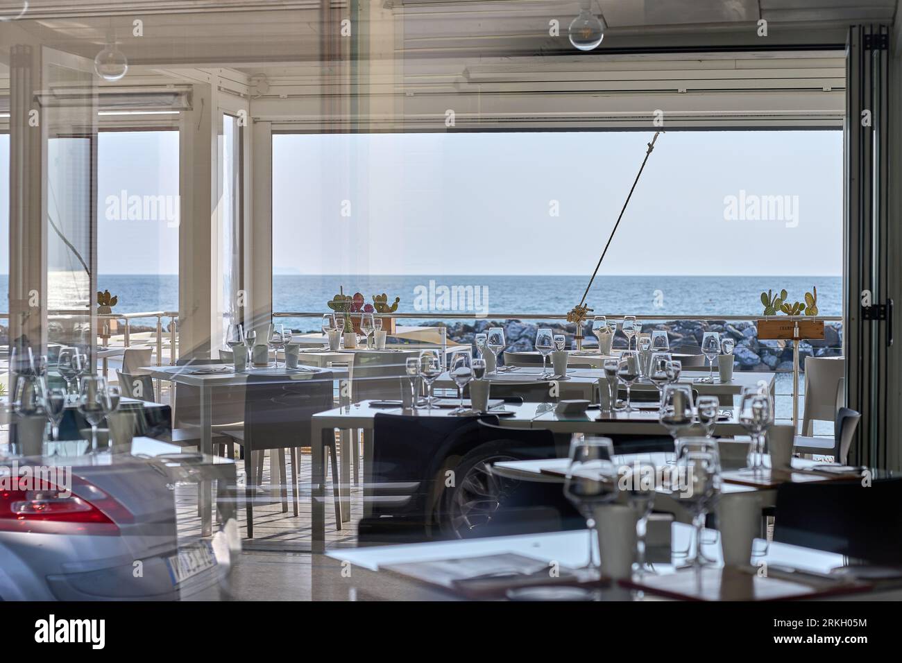 Un restaurant en bord de mer avec une vue panoramique sur l'océan et son rivage sablonneux Banque D'Images