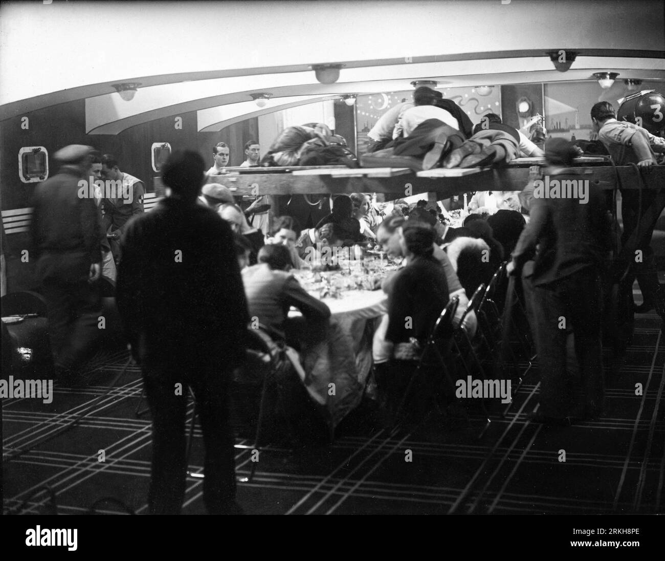 L'équipe de caméra fait un chariot suspendu tourné à travers la table avec des convives dans le bateau fixé pendant le tournage d'un film sonore français non identifié vers 1930 Banque D'Images