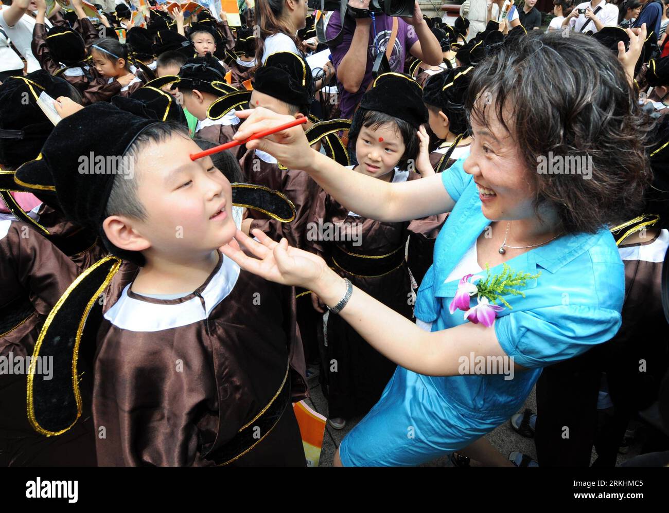 Bildnummer : 55868312 Datum : 31.08.2011 Copyright : imago/Xinhua (110831) -- NANJING, 31 août 2011 (Xinhua) -- un enseignant de l'école primaire du Temple Confucius de Nanjing dessine une tache écarlate sur le front d'un élève, une manière symbolique pour inspirer sa sagesse, lors d'une cérémonie de début de nouvelle année scolaire qui s'est tenue au Temple Confucius à Nanjing, capitale de la province du Jiangsu de l'est de la Chine, le 31 août 2011. Plus de 300 élèves de première année ont récité des paragraphes des Analectes de Confucius, ont rendu hommage à Confucius et ont frappé la cloche des Lumières ici mercredi pour célébrer la prochaine année scolaire. (Xi Banque D'Images