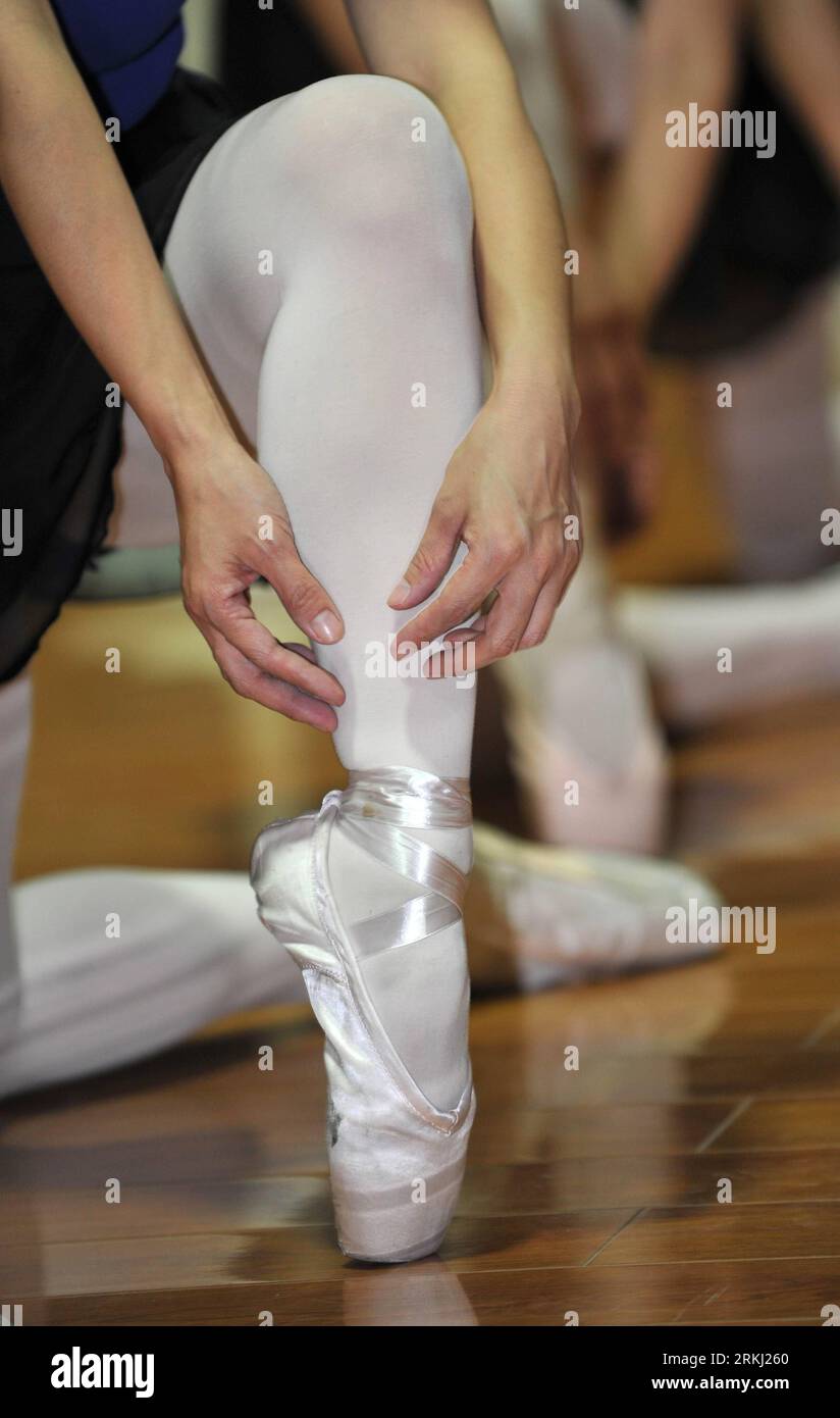 Bildnummer : 55957304 Datum : 13.09.2011 Copyright : imago/Xinhua (110913) -- JINAN, 13 septembre 2011 (Xinhua) -- Une danseuse de ballet ajuste sa chaussure à Jinan, capitale de la province du Shandong de l'est de la Chine, 10 septembre 2011. Vingt amateurs de ballet, âgés en moyenne de 55 ans, ont formé cette troupe de ballet pour poursuivre leurs rêves de danse de ballet. Sans beaucoup de formation professionnelle en danse, ces femmes âgées ont commencé à partir de zéro sous la direction de Ran Yujie, 57 ans, leur entraîneur et pourtant chef d'équipe. De la position debout aux pas en passant par le saut, ils ont fait des progrès petit à petit et ont réalisé de grands f Banque D'Images
