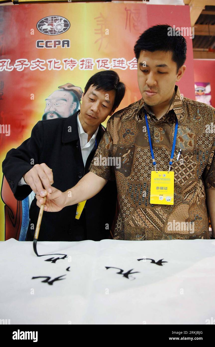 Bildnummer : 56084373 Datum : 23.09.2011 Copyright : imago/XINHUA (110923) -- YINCHUAN, 23 septembre 2011 (XINHUA) -- yuan Surya (à droite) apprend à utiliser le stylo à brosse dans une zone d'exposition de calligraphie chinoise en 2011 China (Yinchuan) Investment and Trade Fair, à Yinchuan, capitale du nord-ouest de la Chine Ningxia hui région autonome, 23 septembre 2011. Yuan Surya, un marchand indonésien qui vend de la nourriture islamique, a participé pour la première fois à la Foire de l'investissement et du commerce chinois de 2011 à Yinchuan. En plus de négocier avec les clients et les partenaires et de vendre ses produits, il a également profité de cette occasion pour obtenir Banque D'Images