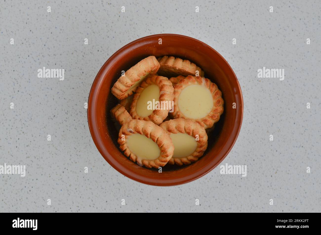 Gros plan de délicieux biscuits sous forme de tartelettes remplies de chocolat blanc, une tentation irrésistible. Biscuits croustillants avec généreux ch blanc Banque D'Images