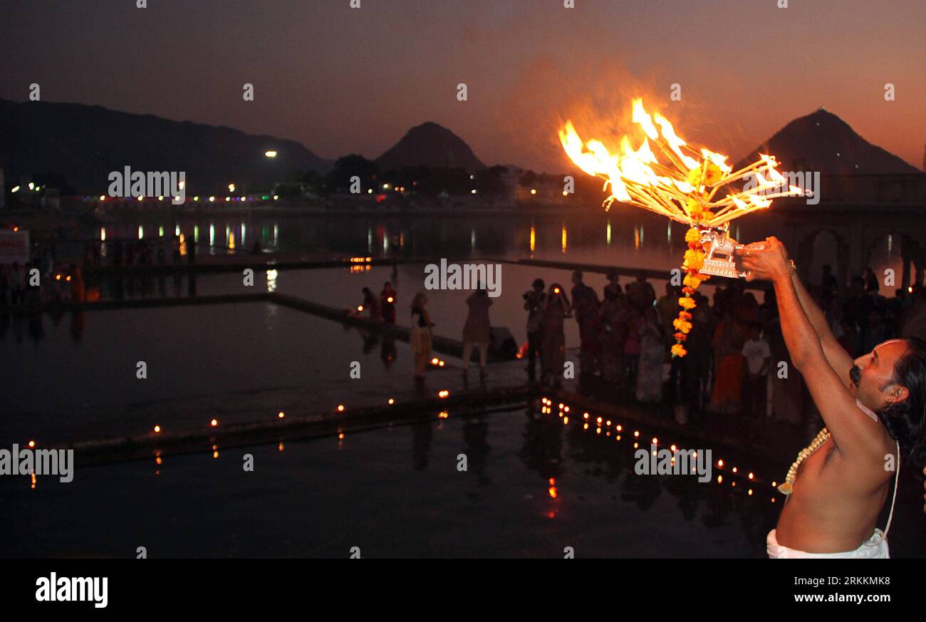 Bildnummer : 56258926 Datum : 07.11.2011 Copyright : imago/Xinhua (111108) -- PUSHKAR (INDE), 8 novembre 2011 (Xinhua) -- Un prêtre hindou exécute arati, un rituel impliquant le tour d'une lampe, à l'occasion de Kartik ekadashi au lac Pushkar, lors de la foire annuelle à Pushkar, Rajasthan, Inde, le 7 novembre 2011. Pushkar, situé sur les rives du lac Pushkar, est un lieu de pèlerinage hindou populaire qui est également fréquenté par les touristes étrangers venant pour sa foire annuelle du bétail et les courses de chameaux. (Xinhua/Stringer) (lr) INDIA-PUSHKAR-FAIR PUBLICATIONxNOTxINxCHN Reisen Gesellschaft religion Hinduismus Banque D'Images