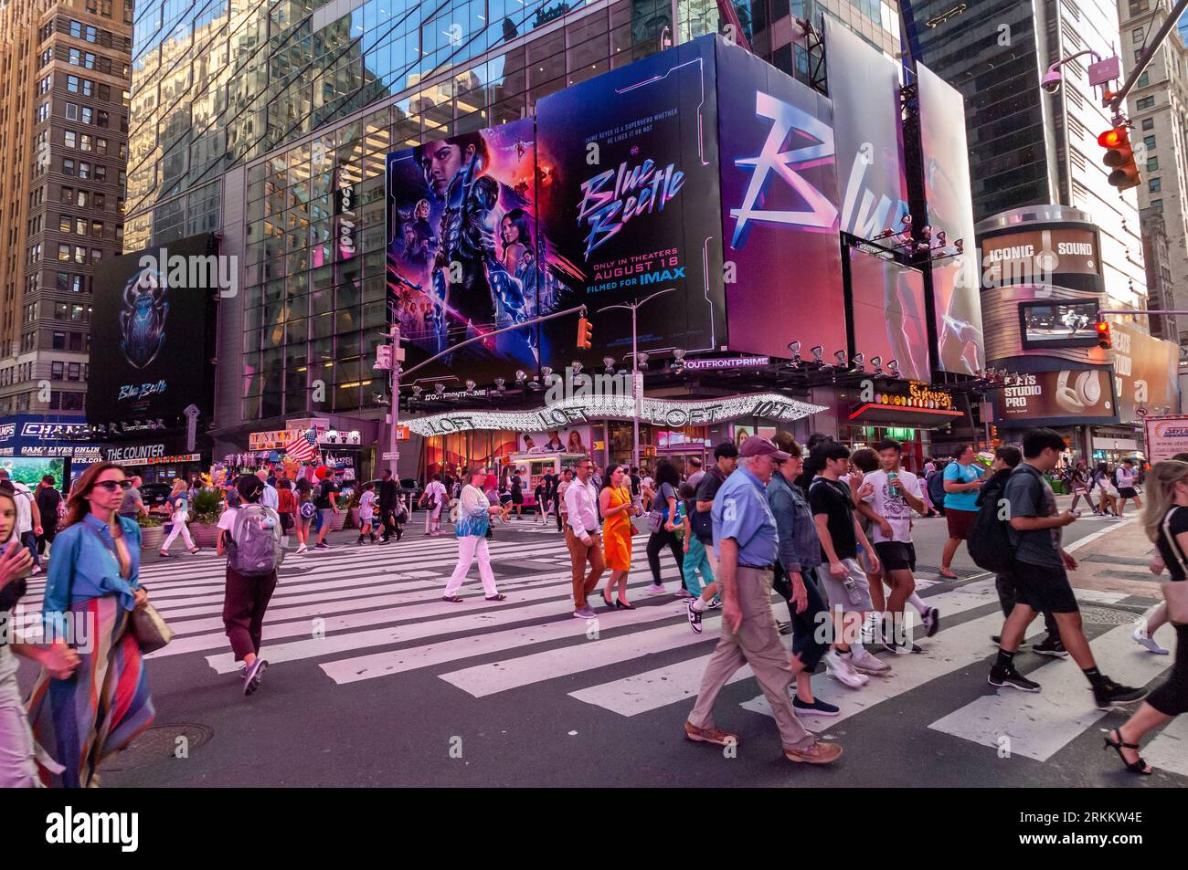Des hordes de gens traversent West 42nd Street sous la publicité pour Warner Bros. PicturesÕ ÒBlue BeetleÓ film à Times Square à New York le vendredi 18 août 2023. Au cours de son week-end de sortie, ÒBlue BeetleÓ a supplanté ÒBarbieÓ en tant que film le plus rentable avec un montant estimé à 25,4 millions de dollars. . (© Richard B. Levine) Banque D'Images