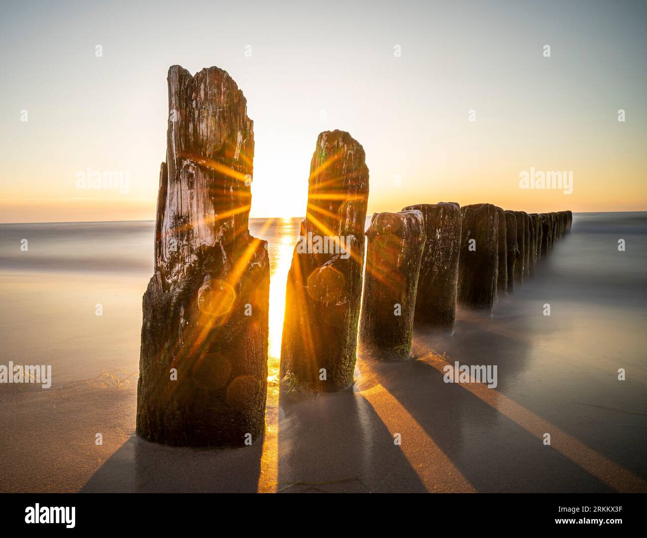 Brise-lames au bord de la mer - coucher de soleil au bord de la mer - rayons du soleil, brise-lames et mer - Dziwnów - Pologne Banque D'Images