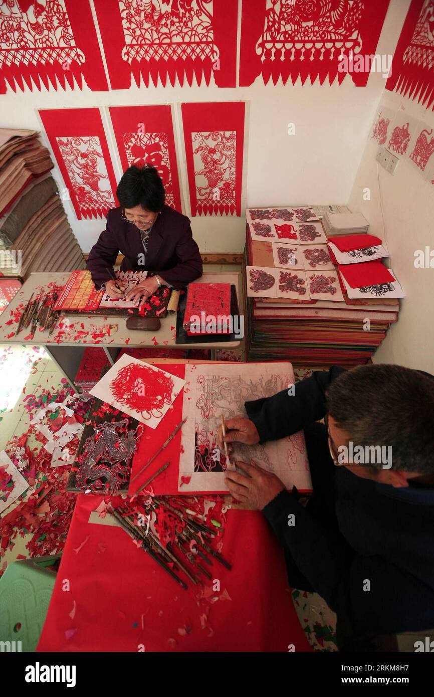Bildnummer : 56542087 Datum : 30.11.2011 Copyright : imago/Xinhua (111202) -- TIANJIN, 2 décembre 2011 (Xinhua) -- Liu Shicun (devant) et sa femme créent des œuvres de sculpture sur papier dans le canton de Fengtai du comté de Ninghe à Tianjin, dans le nord de la Chine, le 30 novembre 2011. Aujourd'hui, face à la montée de la production mécanisée d'œuvres d'art, seuls quelques artisans comme Liu sont encore engagés dans la fabrication des créations de sculpture sur papier à la main. (Xinhua/Ren Lihua) CHINA-TIANJIN-PAPER-CARVING-ARTWORK (CN) PUBLICATIONxNOTxINxCHN Gesellschaft Kunsthandwerk Papierschnitt Scherenschnitt papier schneiden Fotostory China x0x xtm 2011 hoch Banque D'Images