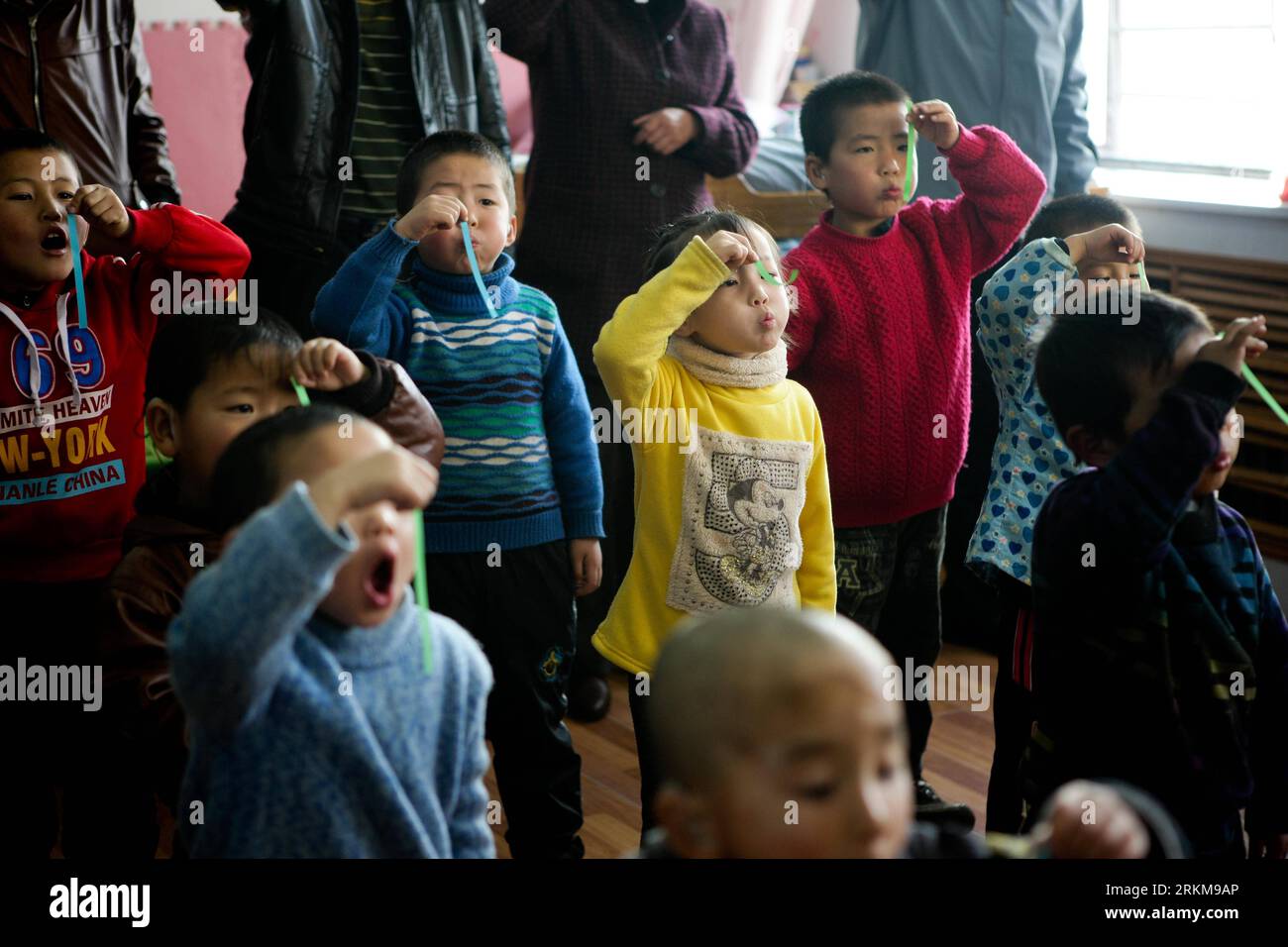 Bildnummer : 56575011 Datum : 25.11.2011 Copyright : imago/Xinhua (111203) -- XI NING, 3 déc. 2011 (Xinhua) -- les enfants malentendants pratiquent la respiration en soufflant des scrips dans un centre de réadaptation auditive à Xi Ning, capitale de la province du Qinghai du nord-ouest de la Chine, 25 novembre 2011. Pour de nombreux enfants sourds, leur capacité auditive partiellement déficiente peut être améliorée à la normale par l'implantation de la cochlée et le port de l'appareil auditif. Au cours des cinq dernières années, la Chine a lancé un projet de réadaptation gratuit pour les enfants déficients auditifs vivant dans la pauvreté, grâce auquel 2 653 enfants ont reçu implante Banque D'Images