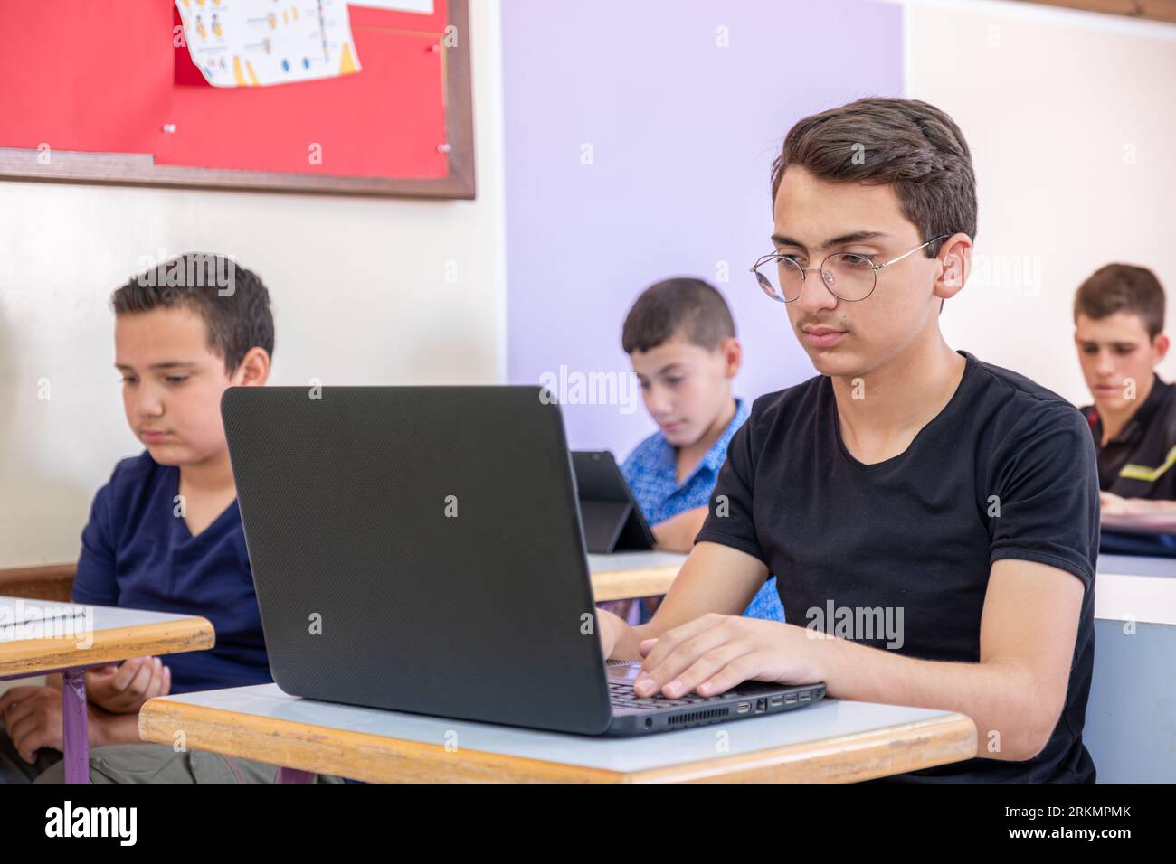 adolescent arabe utilisant un ordinateur portable tout en étudiant à l'école Banque D'Images