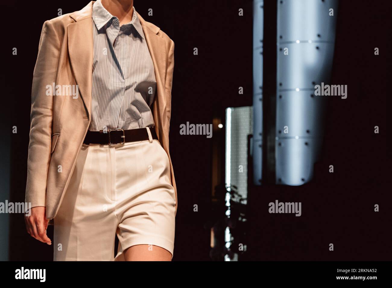 Figure de mannequin femme portant une veste chic beige, un short blanc et une chemise. Photo stylée et tendance. Concept de vêtements de style urbain Banque D'Images