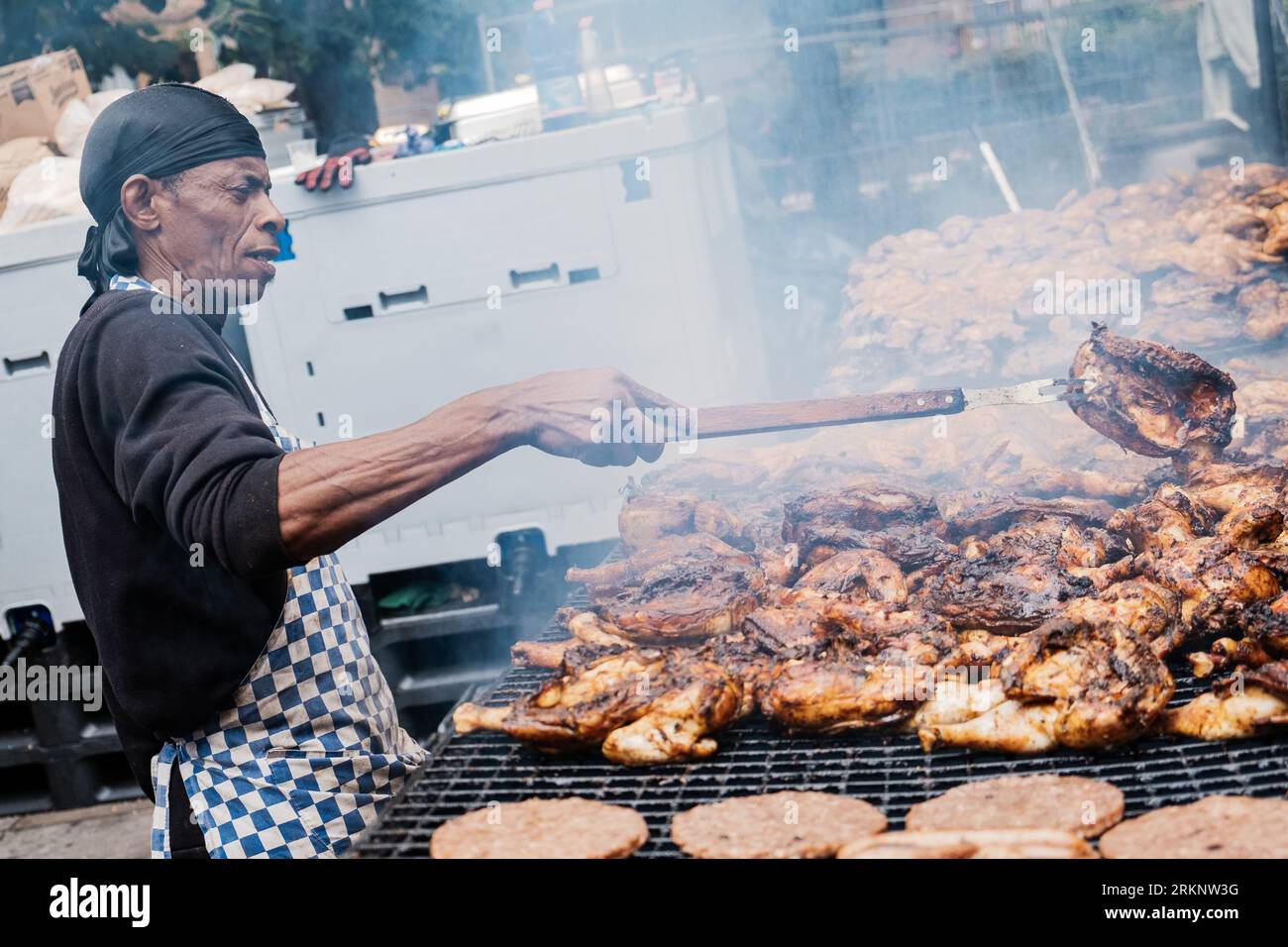 Un chef a vu cuisiner de la nourriture des Caraïbes lors de l'événement. Après 2 ans de pandémie, la plus grande fête de rue en Europe, Notting Hill Carnival est revenu en 2022, étant le 54e carnaval depuis 1966. On s'attend à ce qu'il y ait 2 millions de participants au Carnaval, plus 40 000 bénévoles et 9 000 policiers. Banque D'Images Un chef a vu cuisiner de la nourriture des Caraïbes lors de l'événement. Après 2 ans de pandémie, la plus grande fête de rue en Europe, Notting Hill Carnival est revenu en 2022, étant le 54e carnaval depuis 1966. On s'attend à ce qu'il y ait 2 millions de participants au Carnaval, plus 40 000 bénévoles et 9 000 policiers. Banque D'Images
