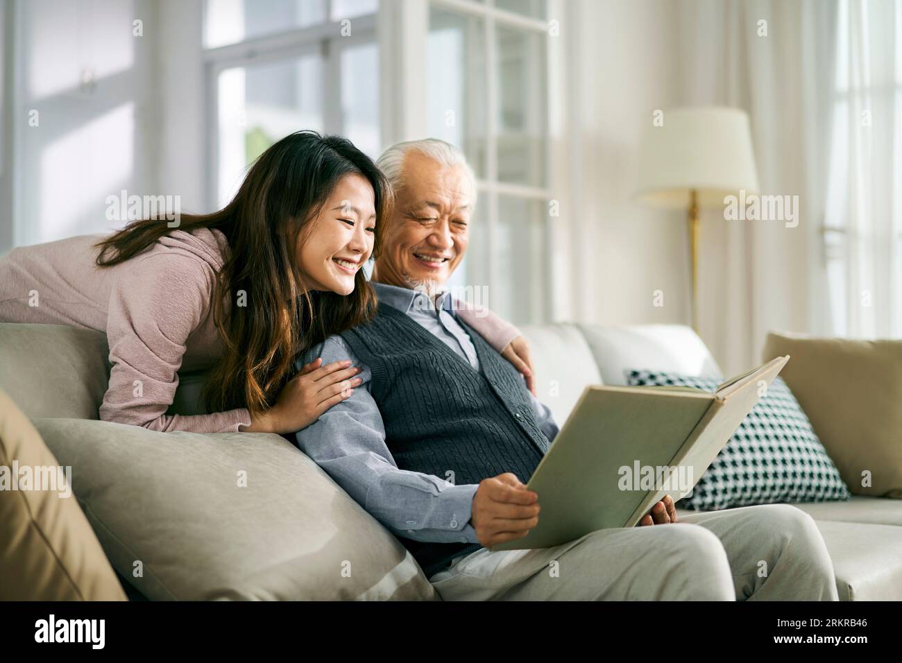 fille adulte asiatique et père aîné appréciant la conversation et le bon temps à la maison Banque D'Images