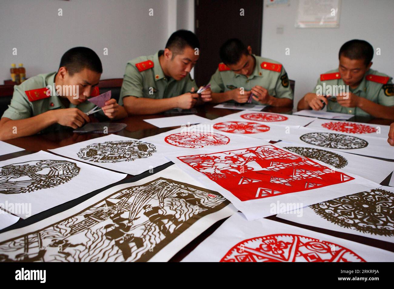 Bildnummer : 58289630 Datum : 30.07.2012 Copyright : imago/Xinhua (120730) -- HEFEI, 30 juillet 2012 (Xinhua) -- des soldats d'une brigade de pompiers apprennent à faire des coupures de papier à Hefei, capitale de la province d'Anhui de l'est de la Chine, 30 juillet 2012. Fu Huakun, un vieil artiste engagé dans le design depuis plus de 40 ans, a visité les pompiers avec un de ses apprentis Qi Shengli lundi, enseignant aux pompiers les compétences de la découpe du papier. (Xinhua/Xu Zijian) (cl) CHINE-ANHUI-HEFEI-POMPIERS-COUPE DE PAPIER (CN) PUBLICATIONxNOTxINxCHN Gesellschaft xda x2x 2012 quer o0 Papierschnitt Schere Banque D'Images