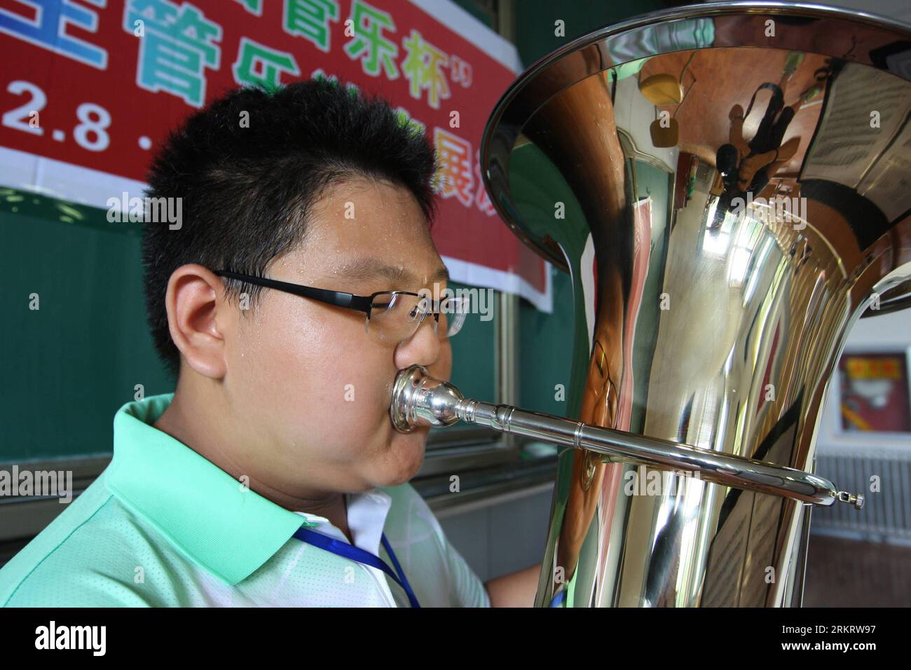 Bildnummer : 58316383 Datum : 06.08.2012 Copyright : imago/Xinhua (120806) -- QINGDAO, 6 août 2012 (Xinhua) -- un garçon rivalise avec son tuba lors de la première exposition solo nationale de musique à vent des élèves du primaire et du secondaire à l'Université de Qingdao à Qingdao, une ville côtière dans la province du Shandong de l'est de la Chine, le 6 août 2012. Les gagnants du premier prix de la première exposition solo de la coupe de musique à vent de Chine pour les jeunes, qui est organisée par l'Association des musiciens chinois, l'Association chinoise pour les groupes symphoniques et les ensembles et le gouvernement populaire de Qingdao, seront exemptés des essais d'instruments à vent wh Banque D'Images