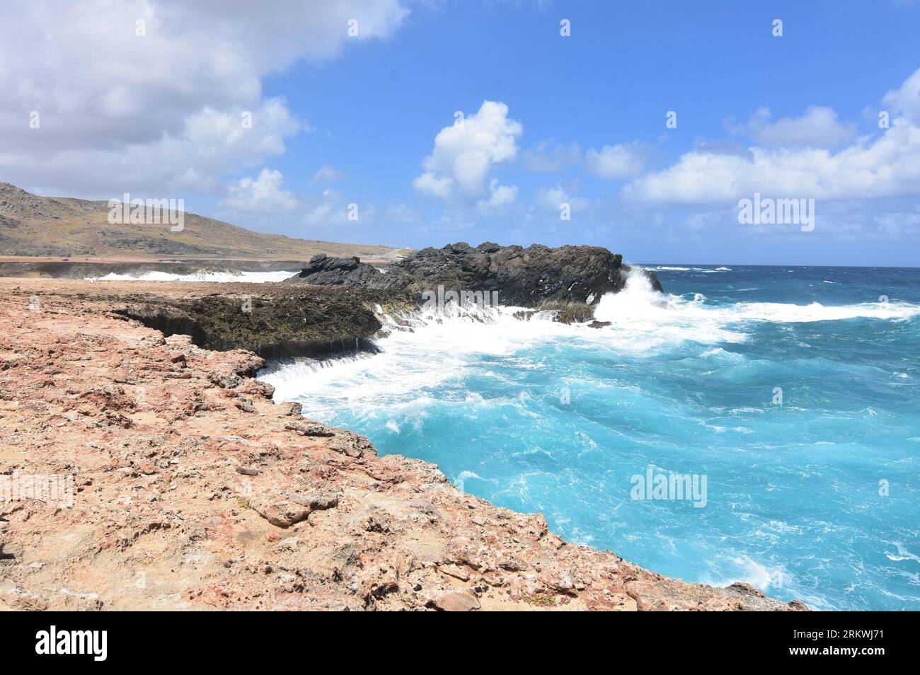 Océan éclaboussant contre les falaises de la mer à Aruba. Banque D'Images