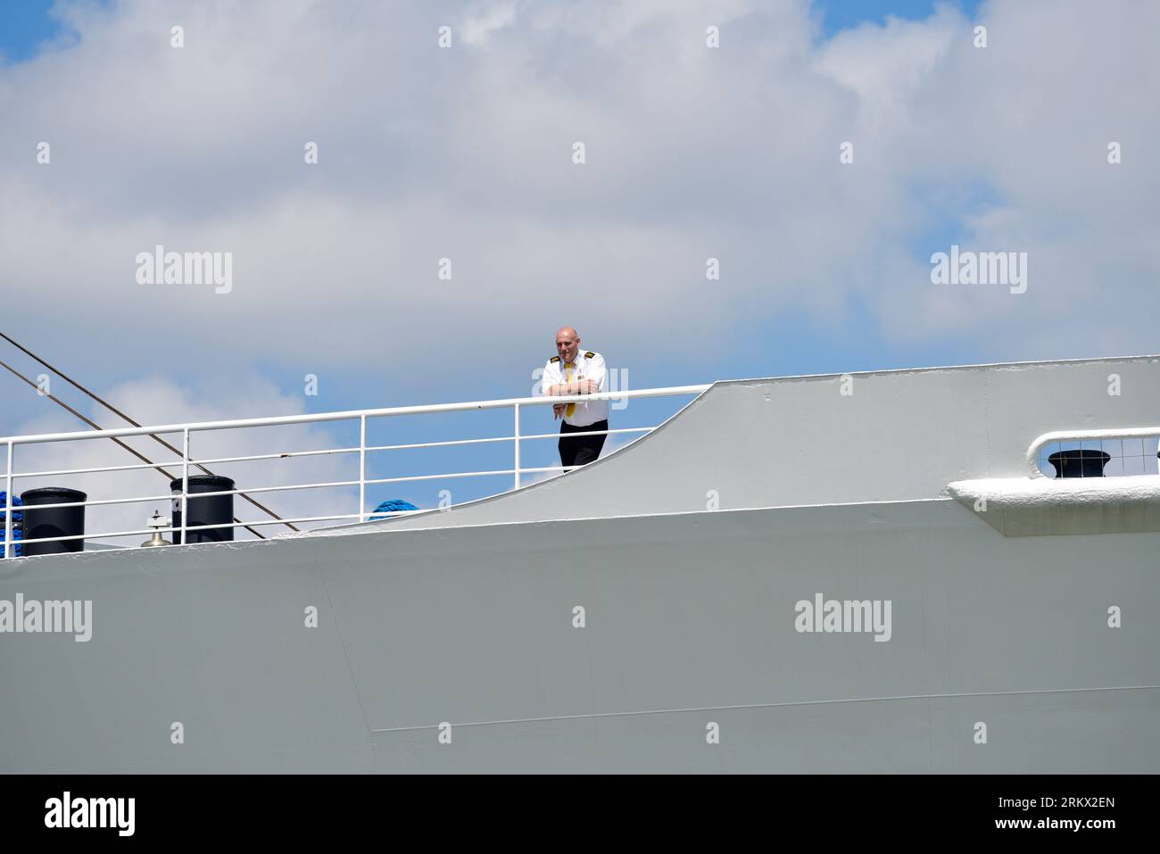 Membre de l'équipage sur le SS Rotterdam Deck officier se tient seul sur un pont avant autrement vide et regarde ce qui se passe sur l'eau en dessous de lui Banque D'Images