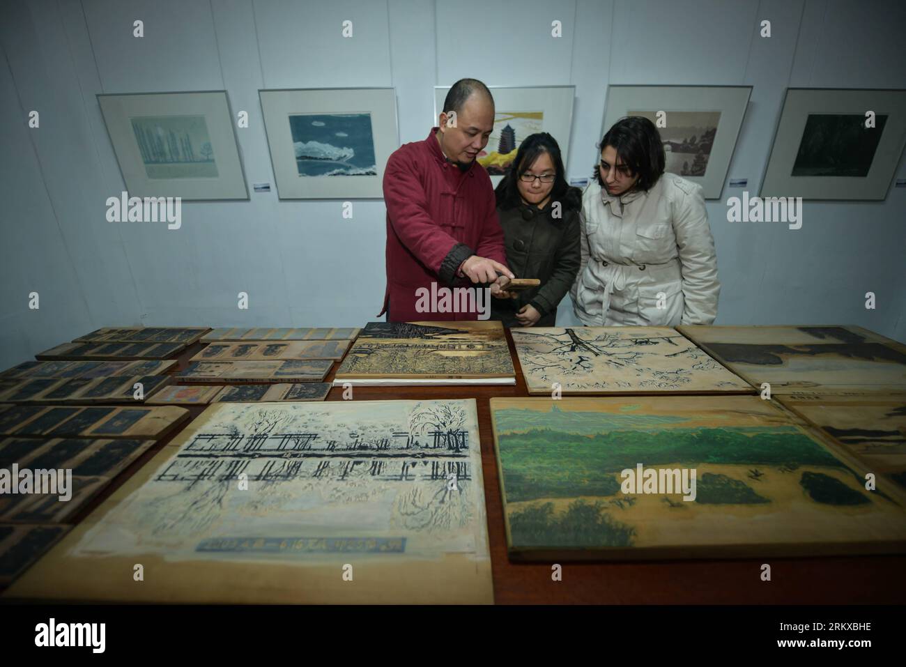 Bildnummer : 58936369 Datum : 20.12.2012 Copyright : imago/Xinhua (121220) -- HANGZHOU, 20 décembre 2012 (Xinhua) -- Wei Lizhong (à gauche), héritier de la technique de peinture sur bois et conservateur du Shizhuzhai Art Museum, présente les œuvres de peinture sur bois aux étudiants étrangers au Shizhuzhai Art Museum à Hangzhou, capitale de la province du Zhejiang de l est de la Chine, le 20 décembre 2012. Des étudiants de pays tels que le Brésil, l'Afrique du Sud et Singapour viennent spécialement pour apprendre les peintures sur bois au musée d'art pendant un mois. La technique de l'impression sur bois a été classée comme un patrimoine culturel intangbile d'état de Chin Banque D'Images