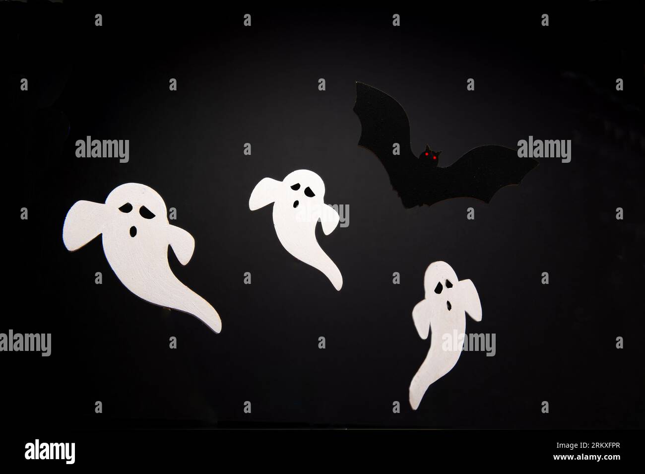 Fantômes et une chauve-souris sur fond noir, c'est une photo pas un dessin. Banque D'Images