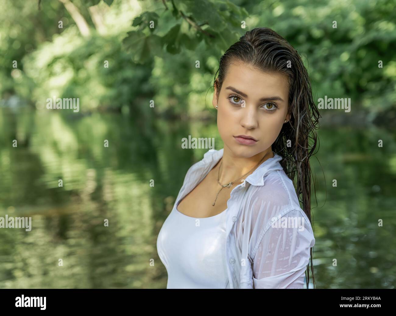 Portrait passionnant d'une jeune fille posant avec les cheveux mouillés dans la rivière. Horizontalement. Banque D'Images