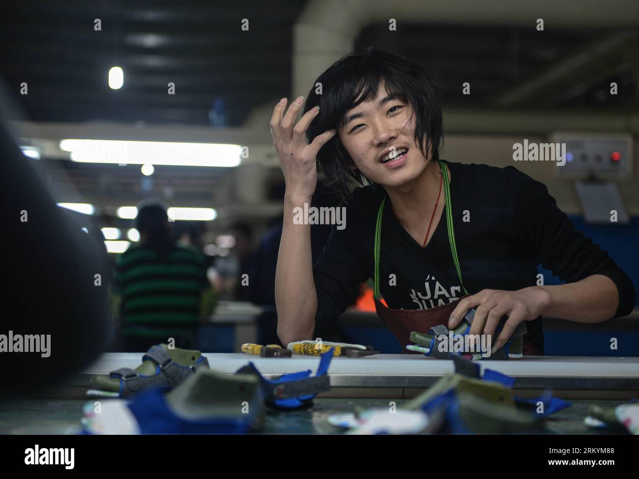 Bildnummer : 59245283 Datum : 17.02.2013 Copyright : imago/Xinhua (130220) -- HANGZHOU, 17 février 2013 (Xinhua) -- Fang Zhuang pose pour une photo dans une usine de chaussures pour laquelle il travaille à Wenling, dans la province du Zhejiang de l'est de la Chine, le 17 février 2013. Fang Zhuang est originaire de Xuchang, dans la province du Henan de Chine centrale, et il est né en 1994. Il venait d'être diplômé du lycée et c'était le premier emploi pour lui. Un groupe de travailleurs migrants qui sont nés après l'année 1990 est devenu une force émergente de l'industrie manufacturière en Chine. Différent des travailleurs migrants de la génération plus âgée, la plupart Banque D'Images
