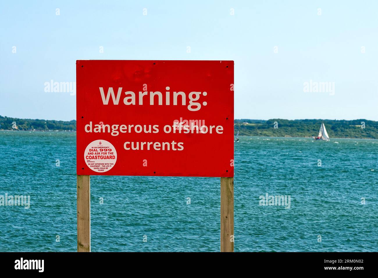 Un grand panneau rouge sur la plage avertissant le public de «courants offshore dangereux» au parc régional de Lepe un jour d'été Hampshire Angleterre Royaume-Uni Banque D'Images Un grand panneau rouge sur la plage avertissant le public de «courants offshore dangereux» au parc régional de Lepe un jour d'été Hampshire Angleterre Royaume-Uni Banque D'Images