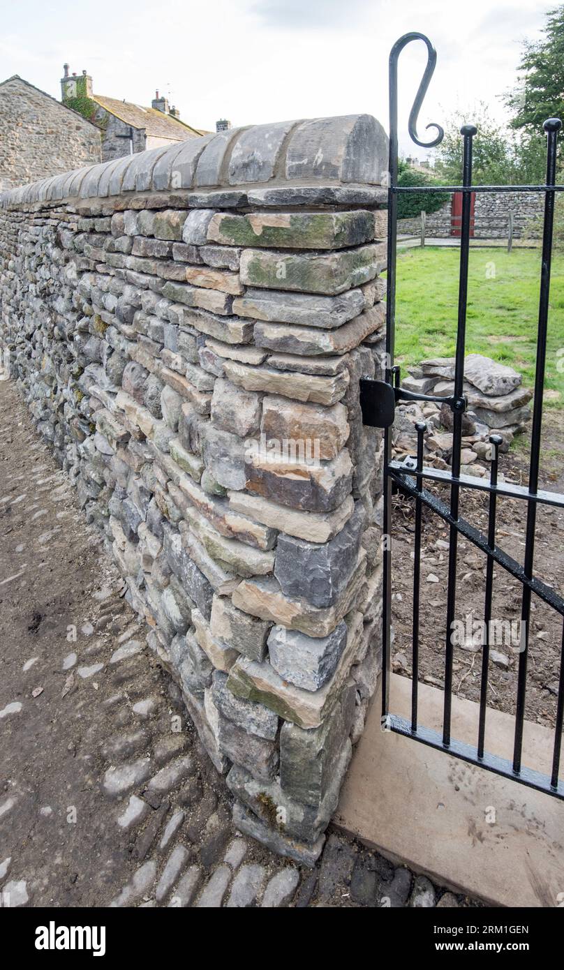 Nouveau mur et portail construits à haut niveau, situé dans l'ancien bâtiment de l'école, peut-être maintenant utilisé comme garagge, à long Preston North Yorkshire Banque D'Images