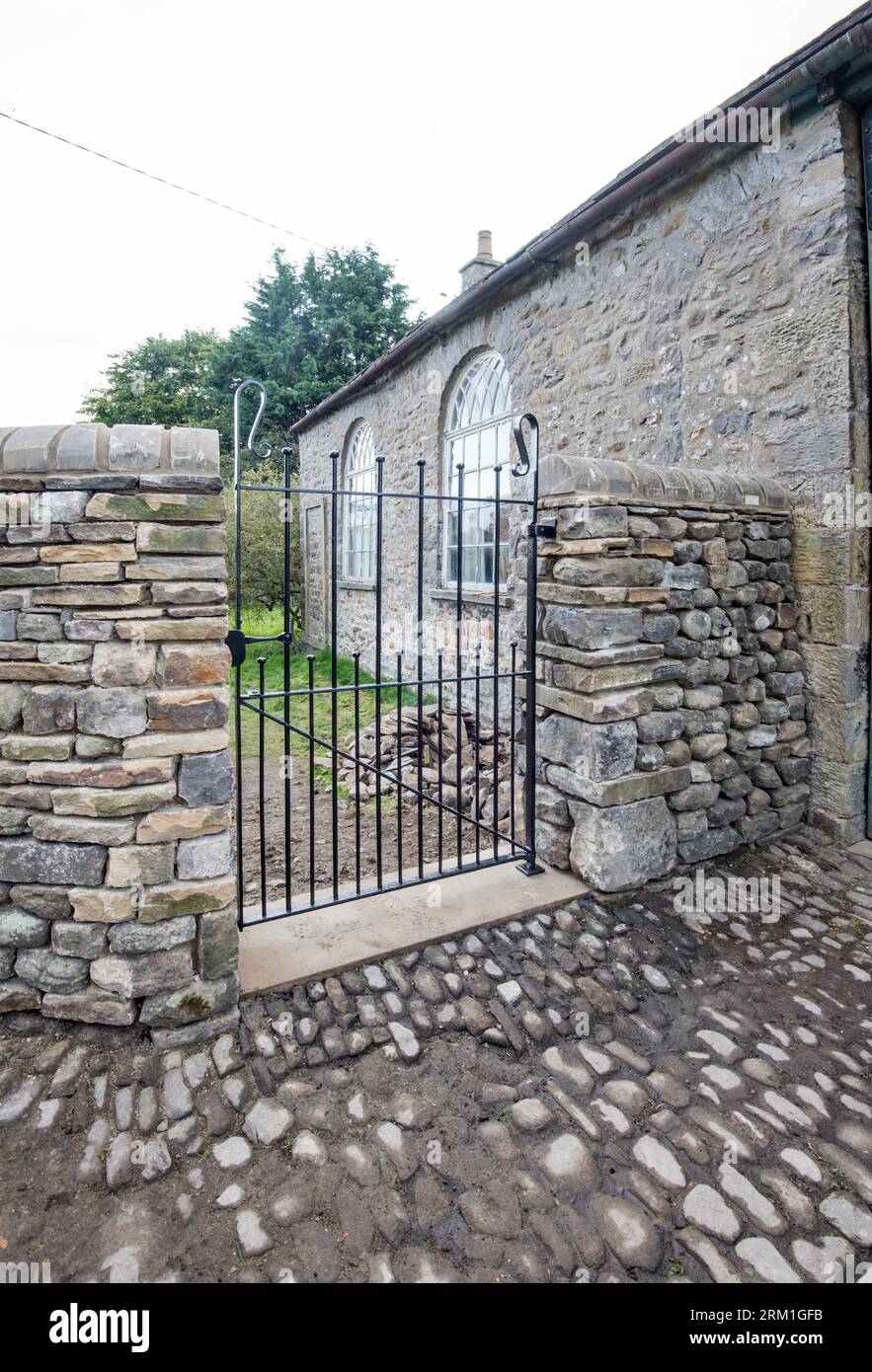 Nouveau mur et portail construits à haut niveau, situé dans l'ancien bâtiment de l'école, peut-être maintenant utilisé comme garagge, à long Preston North Yorkshire Banque D'Images