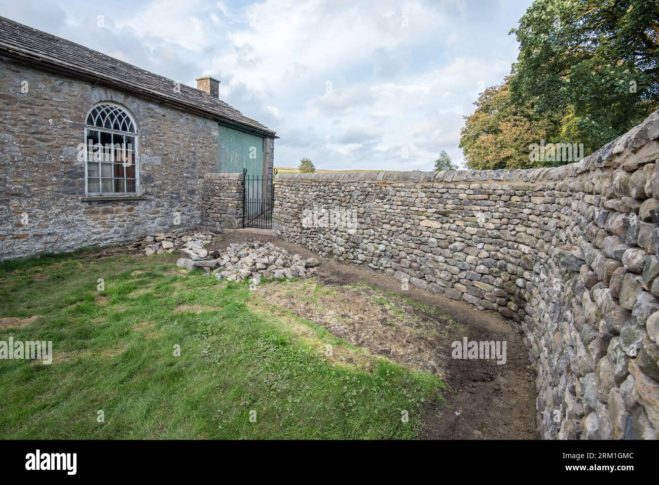 Nouveau mur et portail construits à haut niveau, situé dans l'ancien bâtiment de l'école, peut-être maintenant utilisé comme garagge, à long Preston North Yorkshire Banque D'Images